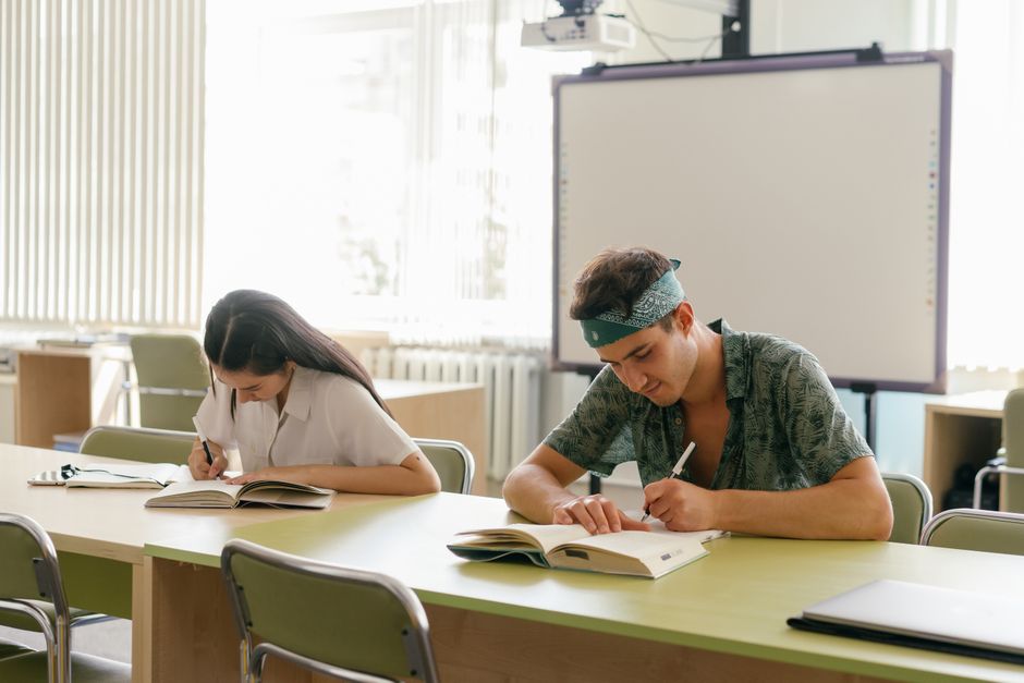Dvoje učenika usredotočeno na učenje u modernoj učionici